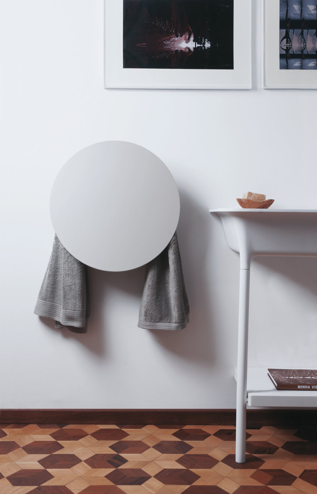 MG12 Geometrici Round towel warmer in white with towels hanging below the round heated panel in a modern bathroom - 20 inch round towel warmer