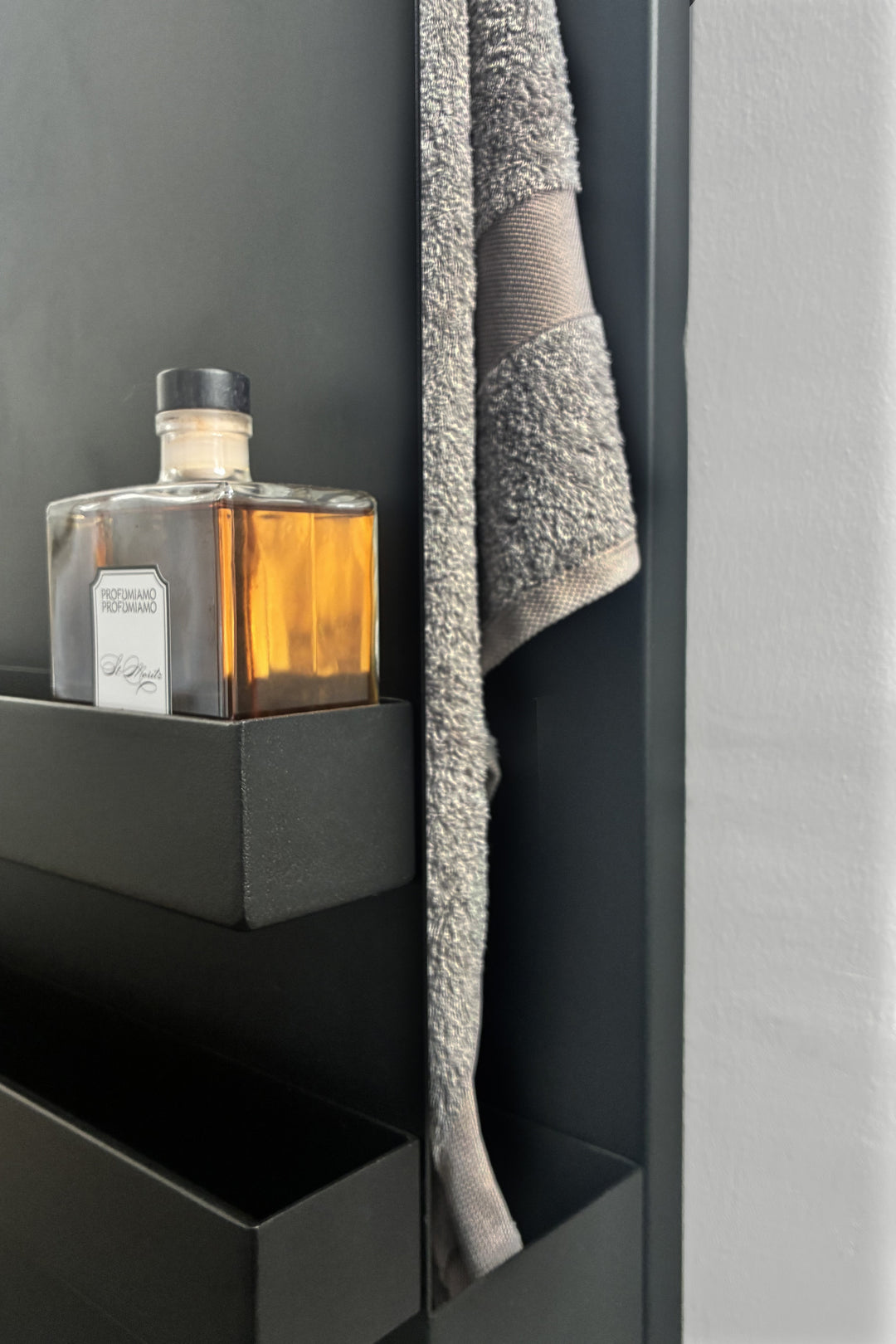 MG12 Geometrici Shelf towel warmer in black - detail of a heated shelf with a towel